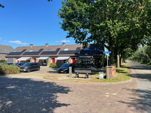 Watertappunt naast een bankje voor een rij met huizen